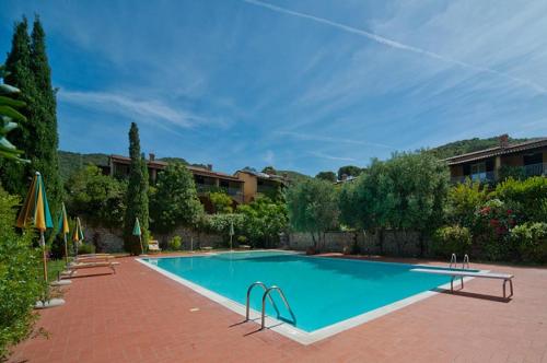 a large swimming pool on a brick patio at Nisportino Domus in Rio nellʼElba