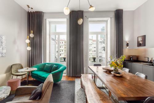 ein Wohnzimmer mit einem Tisch und einem grünen Sofa in der Unterkunft The White Box Boutique House in Porto