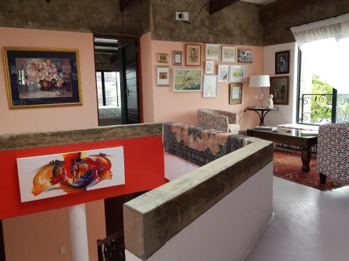 a living room with a wall with paintings on it at Absolute Castillo in Riebeek-Kasteel