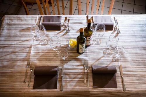 a wooden table with wine bottles and glasses on it at Hotel Agriturismo Al Luogo Del Giulio in Maniago
