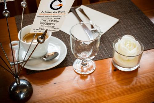 a table with two glasses and a cup of coffee at Hotel Agriturismo Al Luogo Del Giulio in Maniago