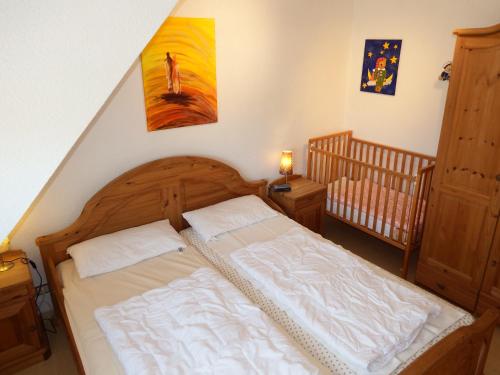 a bedroom with a bed and a baby crib at Strandmensch Dornumersiel in Dornum