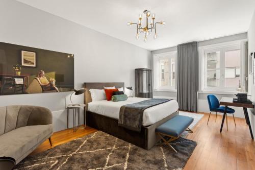 a bedroom with a bed and a desk and a couch at The White Box Boutique House in Porto