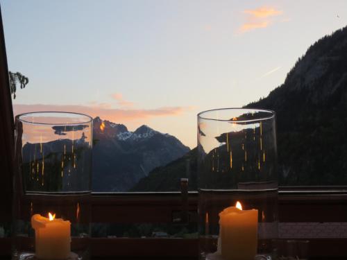 two candles in front of a window with mountains at Hotel Sonnblick in Wald am Arlberg