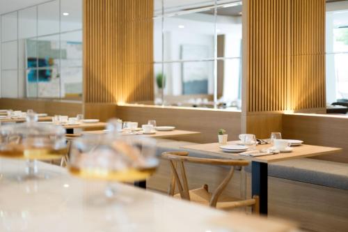 a restaurant with wooden tables and chairs and windows at Bordoy Alcudia Port Suites - Adults Only in Port d'Alcudia