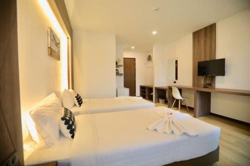 a hotel room with two beds and a desk at Phuket Airport Place in Nai Yang Beach