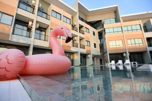 a inflatable pink flamingo sitting in a pool in front of a building at Phuket Airport Place in Nai Yang Beach