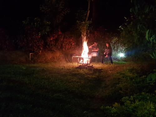 a group of people sitting around a fire at night at THE SUVISTARA WAYANAD KERALA in Meenangadi