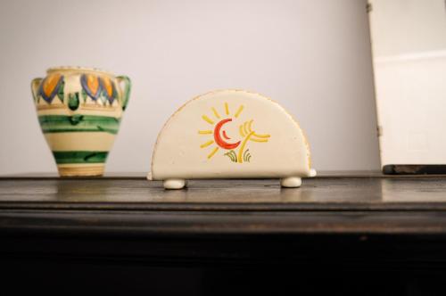 a small object on a table next to a vase at Dimora Storica Palazzo Didonna in Rutigliano