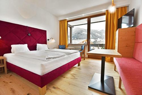 a hotel room with a large bed and a couch at Hotel NockResort in Bad Kleinkirchheim