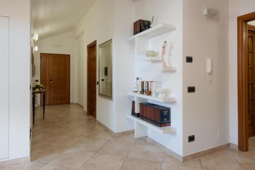 a hallway with white walls and shelves with books at L'Insolita Reggia in Caserta