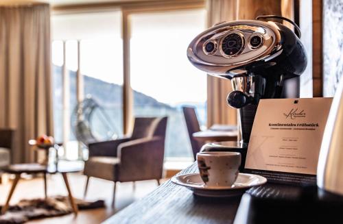 a camera sitting on a table with a cup of coffee at Boutique Hotel Kircher in Sarntal