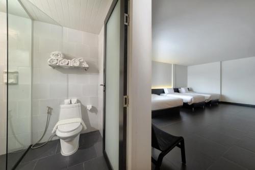 a bathroom with a toilet and two beds at iSilver Hotel in Chiang Mai