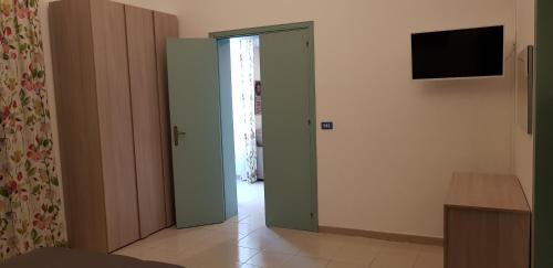Zimmer mit einer offenen Tür und einem TV an der Wand in der Unterkunft VILLA RISORGIMENTO in centro sul corso principale in Scoglitti