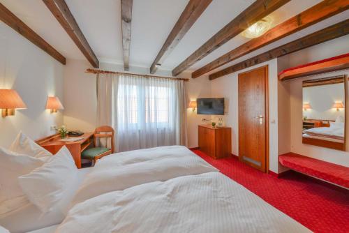 ein Hotelzimmer mit einem großen Bett und einem Spiegel in der Unterkunft Mayers Waldhorn - zwischen Reutlingen und Tübingen in Tübingen