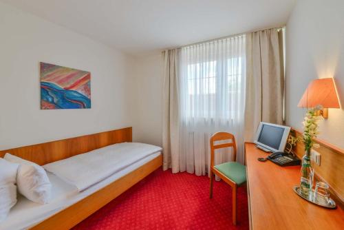 a bedroom with a bed and a desk with a computer at Mayers Waldhorn - zwischen Reutlingen und Tübingen in Tübingen