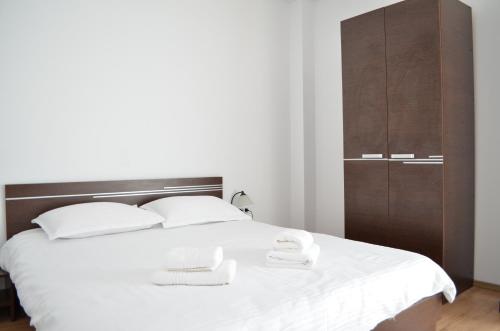 a bedroom with a bed with two white towels on it at Alexys Residence 6 in Iaşi