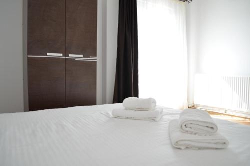 zwei Handtücher auf einem weißen Bett in der Unterkunft Alexys Residence 8 in Iaşi