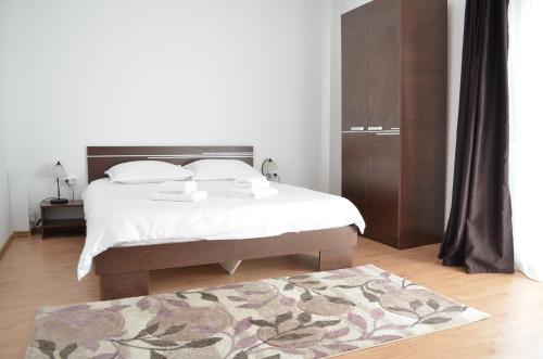 ein Schlafzimmer mit einem Bett und einem Teppich auf dem Boden in der Unterkunft Alexys Residence 8 in Iaşi