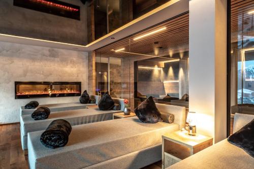 a room with four beds and a fireplace at Boutique Hotel Kircher in Sarntal