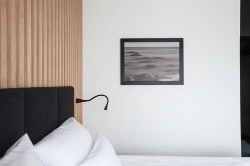 a bedroom with a bed and a picture on the wall at Hotel Shuum Boutique - Destigo Hotels in Kołobrzeg