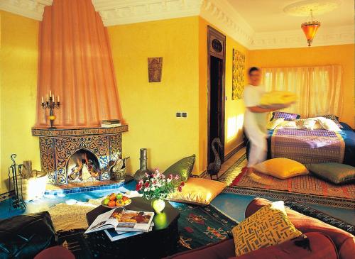 a man running through a living room with a fireplace at Rive Du Lac in Lalla Takerkoust