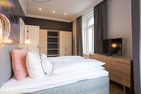 Schlafzimmer mit einem großen weißen Bett und einem TV in der Unterkunft My Home in Vienna - Smart Apartments - Margareten in Wien