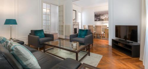 a living room with a couch and a table and a television at Résidence Charles Floquet in Paris