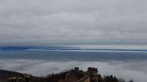 a castle on top of a mountain above a sea of clouds at Guest House Maria in Sighnaghi