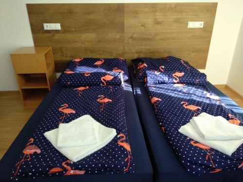 a bed with a blue bedspread with crabs on it at Acopark Vendégház in Debrecen