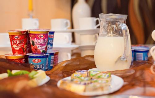 a table topped with a jar of milk and a donut at Hotel Bursztyn in Kalisz