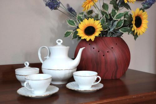 a table with two tea cups and a vase with flowers at Hotel Ristorante Château in Aymavilles