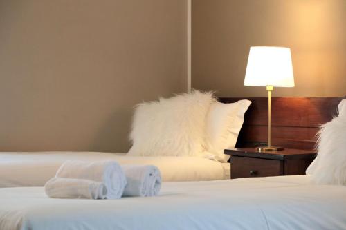 a hotel room with two beds with towels and a lamp at Hotel Ristorante Château in Aymavilles