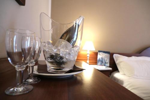 two wine glasses and a plate on a table at Hotel Ristorante Château in Aymavilles