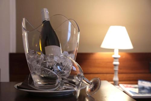 a bottle of wine in a glass container next to a lamp at Hotel Ristorante Château in Aymavilles