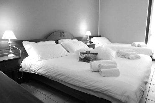 two beds in a hotel room with towels on them at Hotel Ristorante Château in Aymavilles