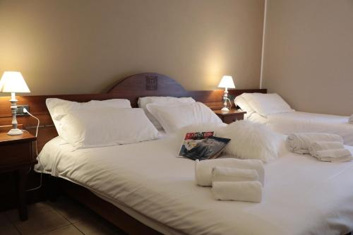 a bedroom with two beds with white sheets and pillows at Hotel Ristorante Château in Aymavilles