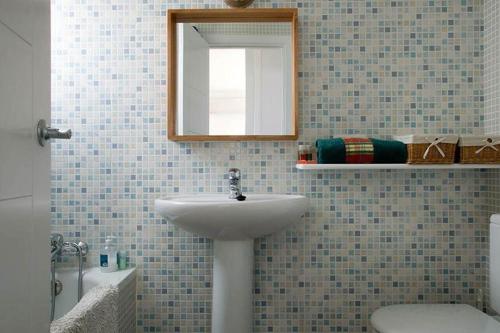 a bathroom with a sink and a mirror and a toilet at Ático en el mar in Alcossebre