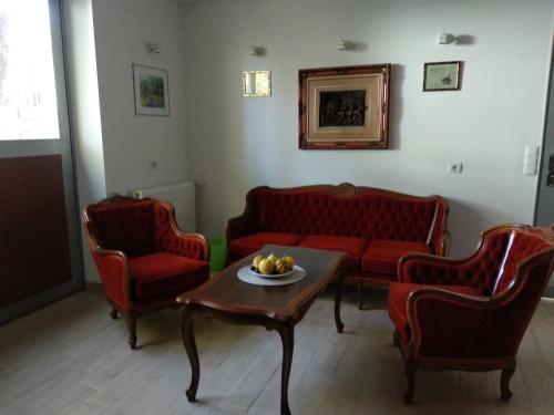 a living room with red couches and a table at Acopark Vendégház in Debrecen