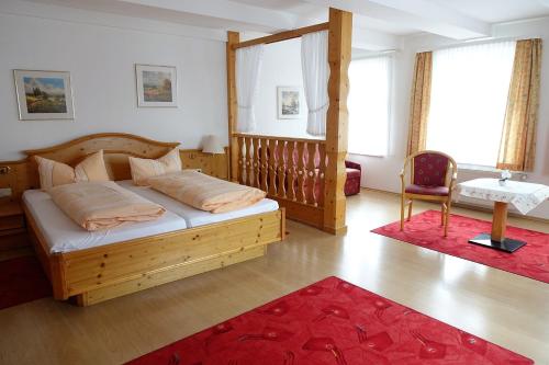 Schlafzimmer mit einem Holzbett und einem roten Teppich in der Unterkunft Pension "Am Nico" in Wernigerode
