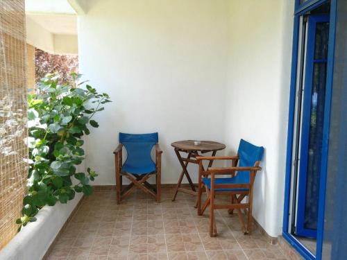 a patio with two chairs and a table and a plant at Archondissa Beach Aparthotel in Therma