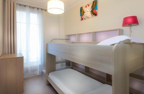 a room with a bunk bed with a lamp and a window at Résidence Charles Floquet in Paris