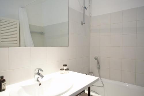a bathroom with a sink and a mirror and a tub at Résidence Charles Floquet in Paris