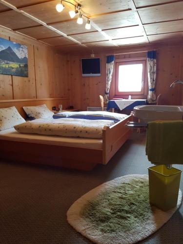 a large bedroom with two beds and a television at Pension Vallüla in Galtür