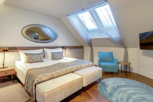 a bedroom with a bed and a blue chair at Hotel Vilnia in Vilnius