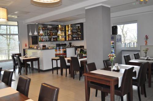 a restaurant with tables and chairs and a bar at Hotel Trojan in Lądek-Zdrój