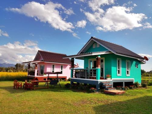 a colorful house with a picnic table in front of it at Ban Thung Talay Mok Chiangdao in Chiang Dao
