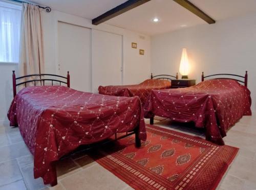 two beds with red covers in a room at Hedley Villa Guest House in Leamington Spa
