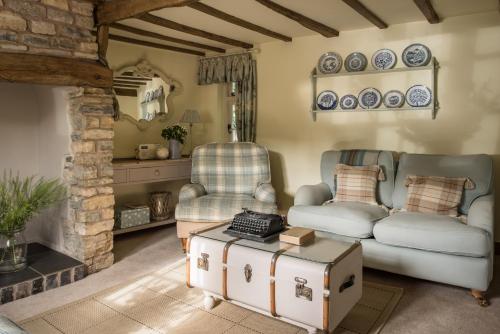 ein Wohnzimmer mit Couch und Tisch in der Unterkunft Old Fox Cottage in Evesham