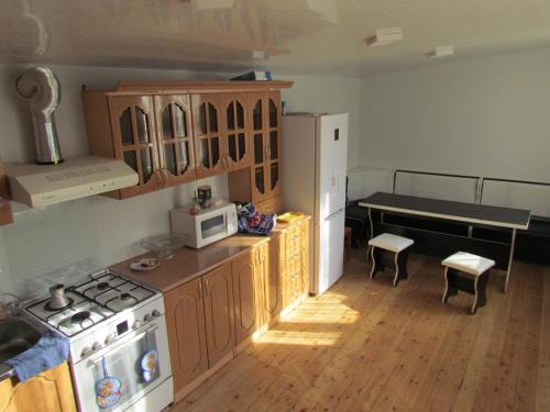 a kitchen with a stove and a white refrigerator at Arsego Hostel in Vanadzor